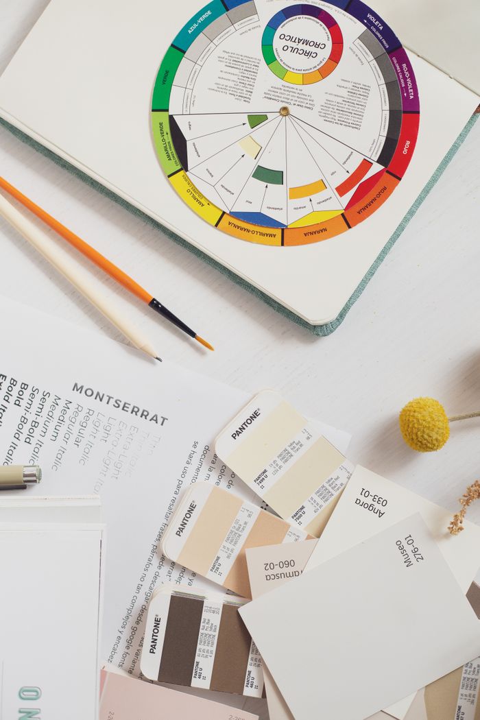 Top view of a creative workspace featuring color swatches, pencils, and design materials, ideal for branding projects.